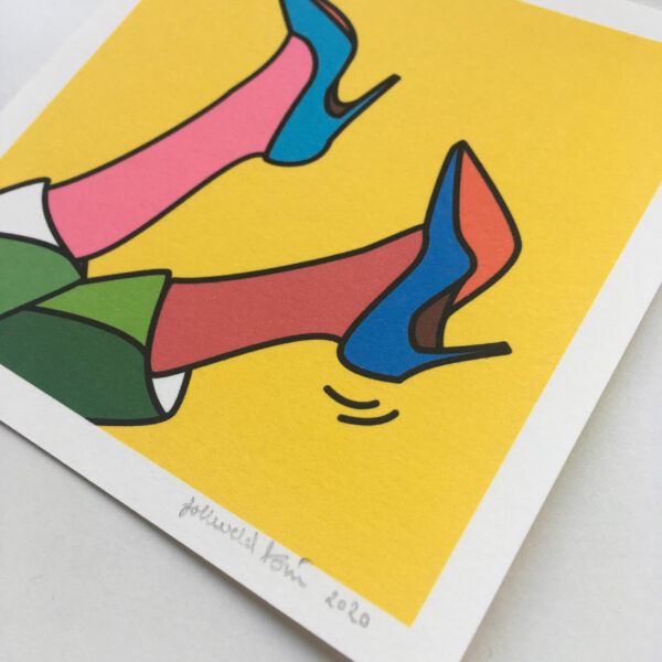Close-up of a mini art print that shows an illustration of two feet with heels up in the air.